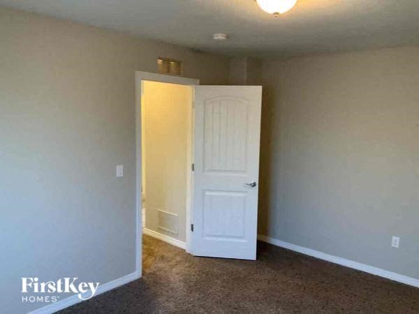 an empty room with a white door and a closet