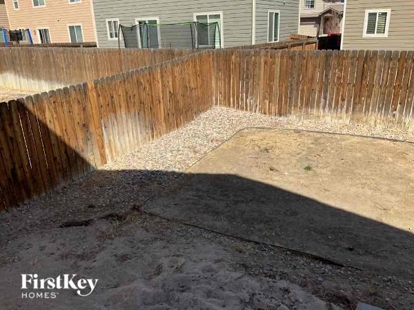 a wooden fence in a yard with a house in the background