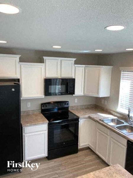 a kitchen with black appliances and white cabinets