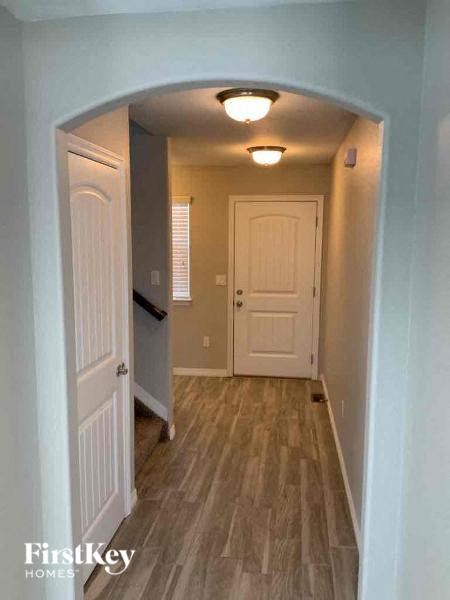 a hallway with a white door and wood flooring