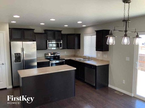 an updated kitchen with black cabinets and stainless steel appliances