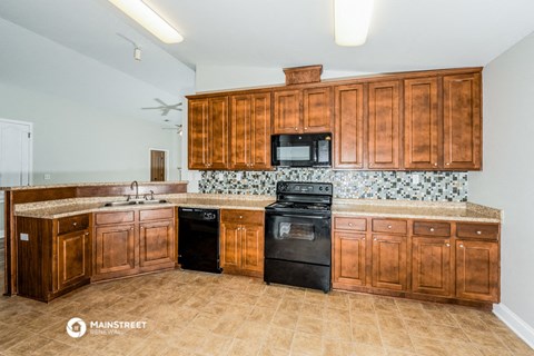 a kitchen with wooden cabinets and a black dishwasher and a sink