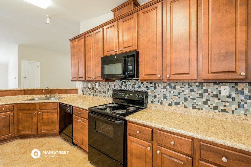a kitchen with wooden cabinets and a black stove and microwave