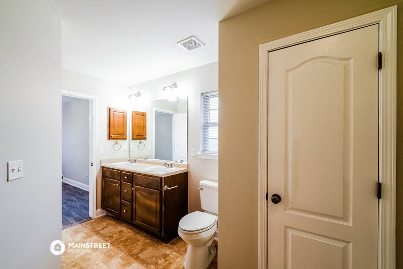 a bathroom with a toilet and a sink and a mirror