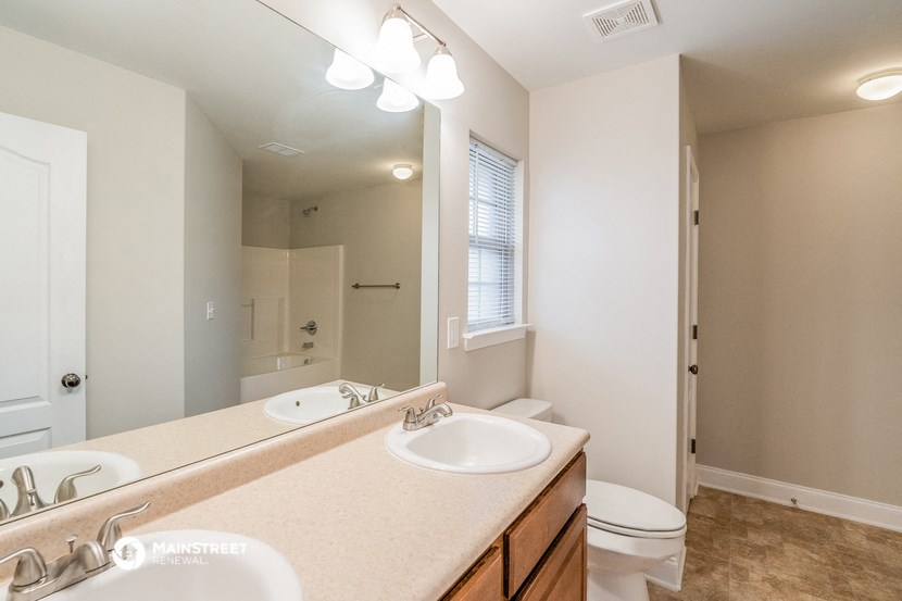 a bathroom with two sinks and a toilet and a mirror
