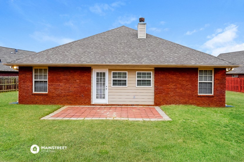 the front of a brick house with a white garage door
