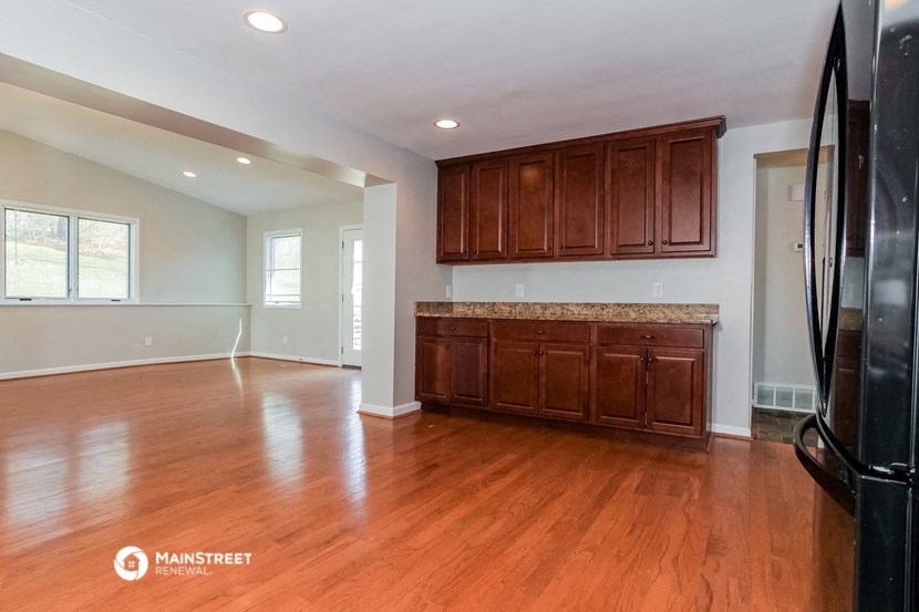 an empty kitchen with wood flooring and wooden cabinets