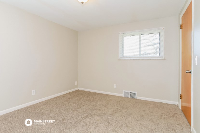 a bedroom with a carpeted floor and a window