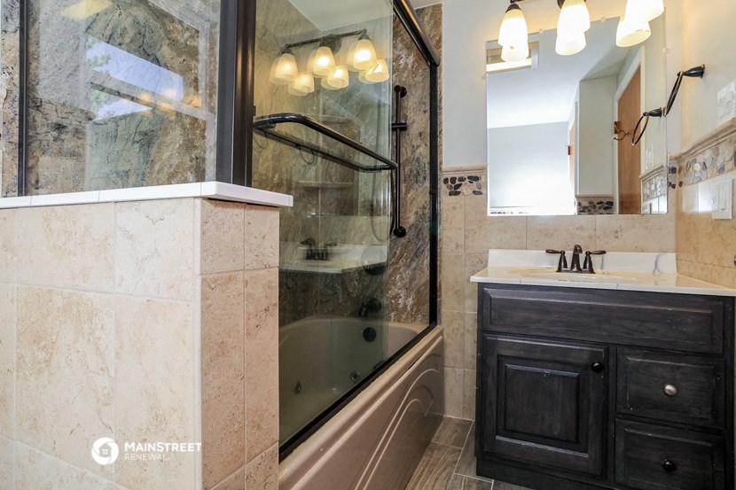 a bathroom with a tub and a shower and a sink