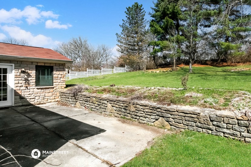 a stone retaining wall in front of a house