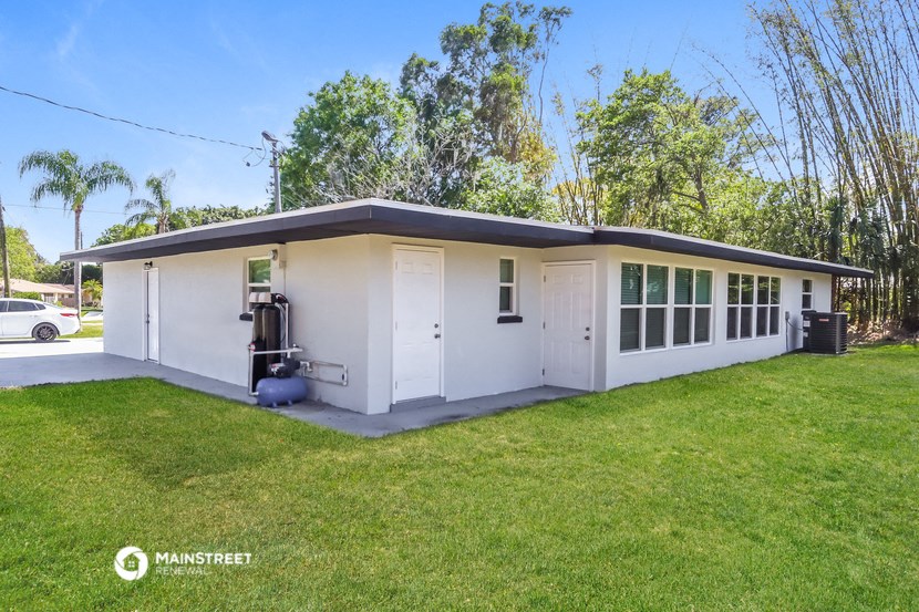a small white building with a gas pump in the front
