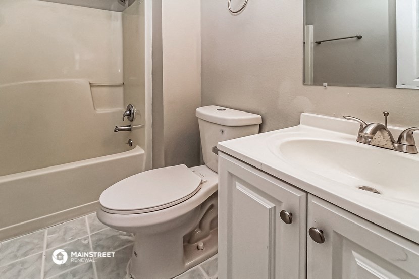 a white bathroom with a toilet and a sink