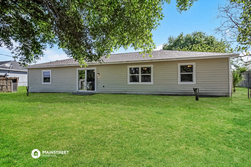 a white house with a yard and a tree