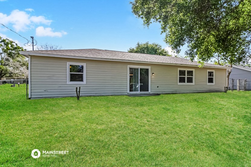 a small white house with a yard and a tree