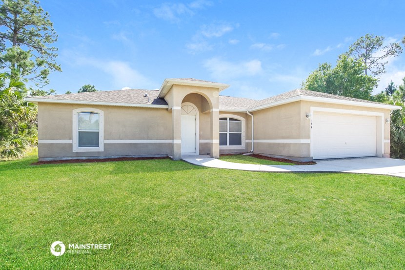 a beige house with a lawn and a white garage door