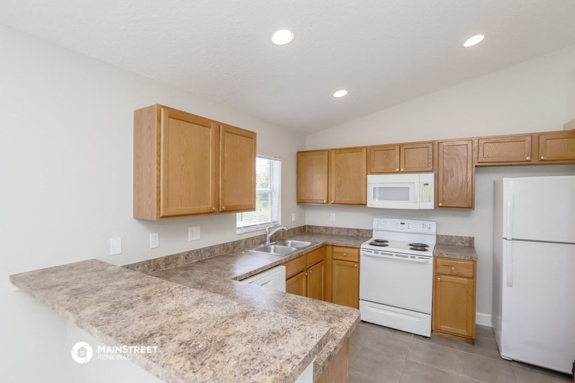 a kitchen with wooden cabinets and white appliances and granite counter tops