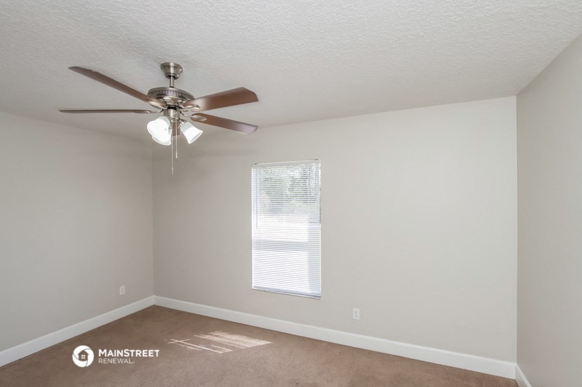 a living room with a ceiling fan and a window