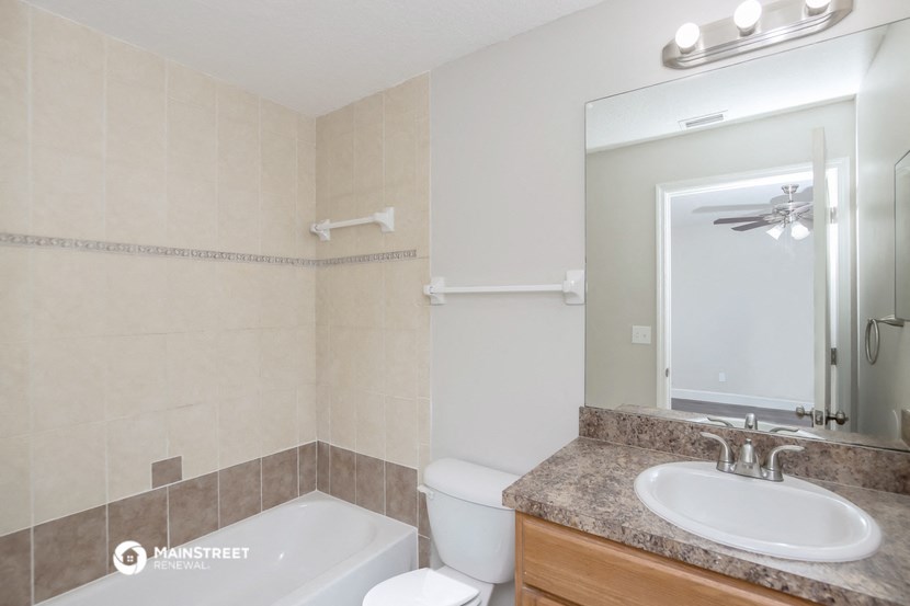 a bathroom with a sink toilet and mirror and a tub