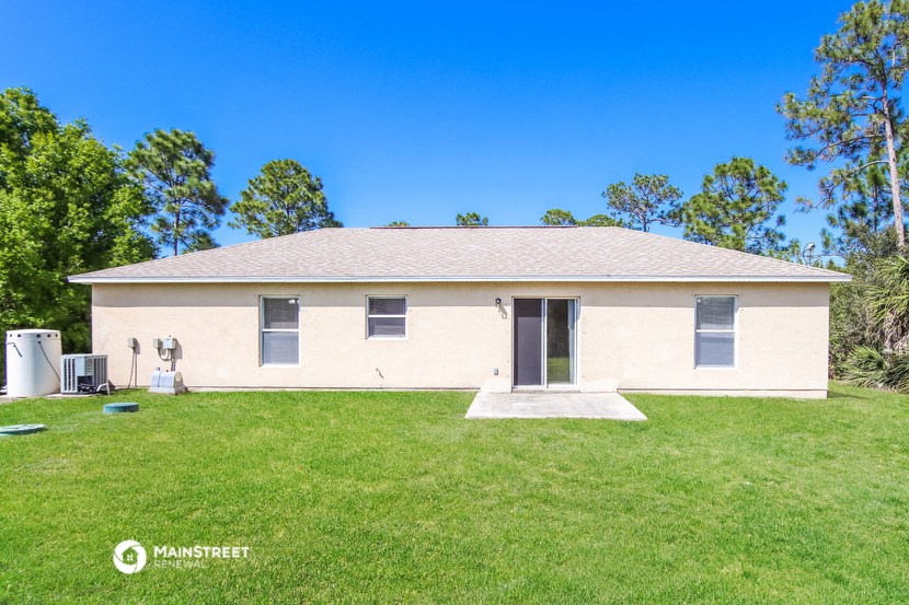 a white house with a grassy yard and trees