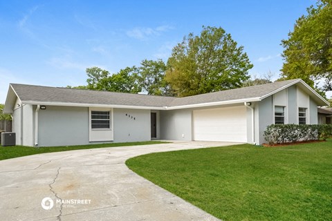 a white house with a driveway and a lawn