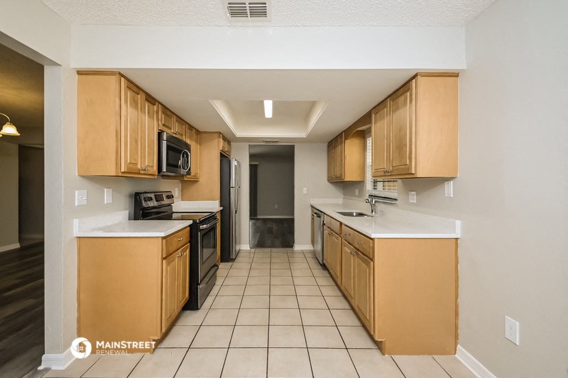 a kitchen with wooden cabinets and a stove and a sink