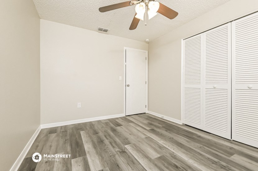 the living room of our studio apartment atrium with wood flooring and ceiling fan