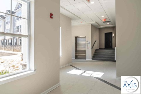 a lobby with a large window and a staircase in a building