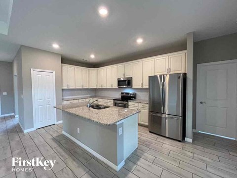 a kitchen with a island and a stainless steel refrigerator