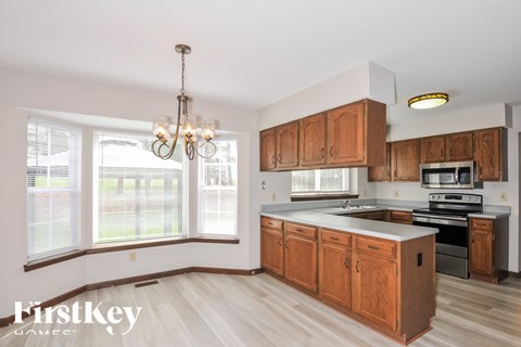 A kitchen with wooden cabinets and a chandelier.