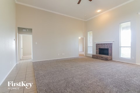 a living room with a fireplace and a carpeted floor