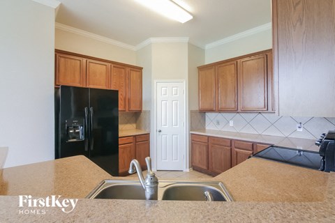 a kitchen with wooden cabinets and a sink and a refrigerator