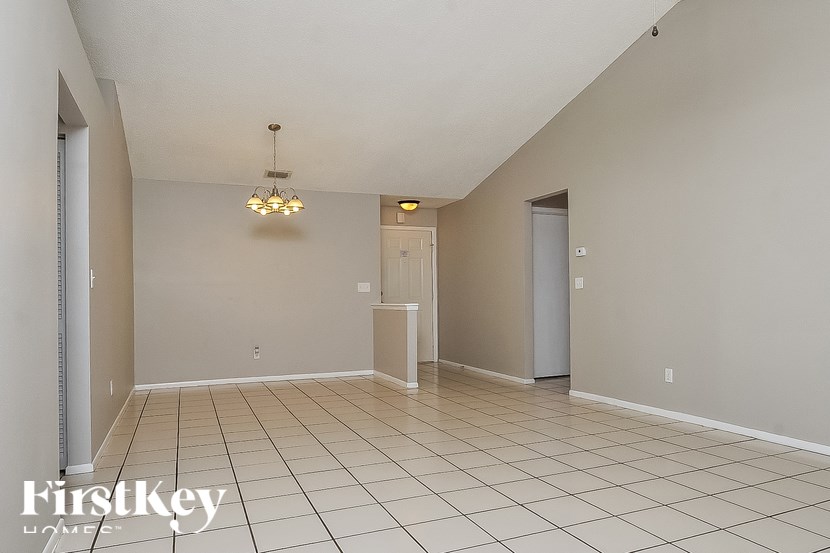 A spacious room with a chandelier and two doors.