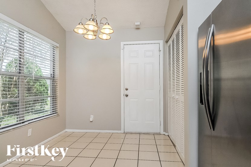 A kitchen with a stainless steel refrigerator and a white door.