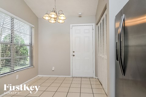 A kitchen with a stainless steel refrigerator and a white door.