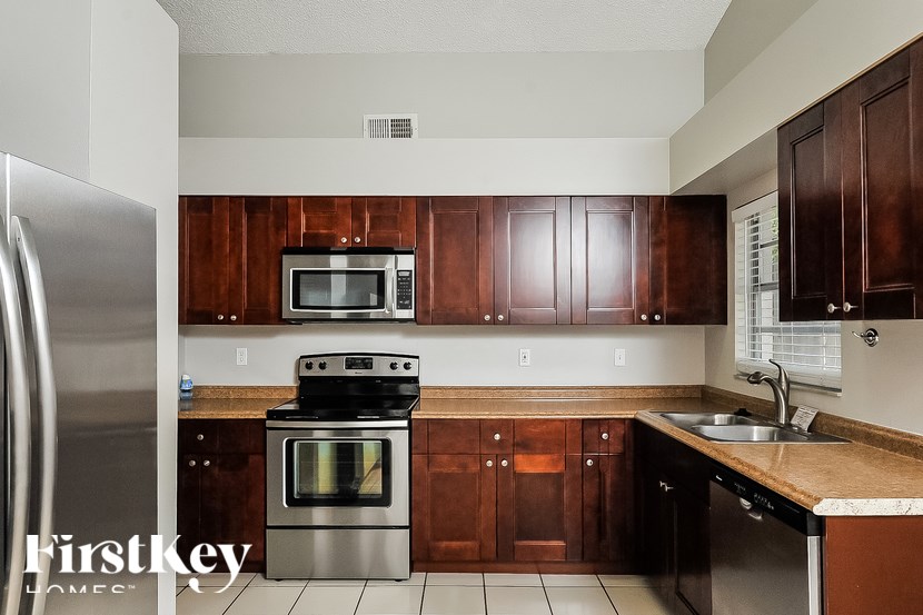 A kitchen with wooden cabinets and a stainless steel refrigerator.