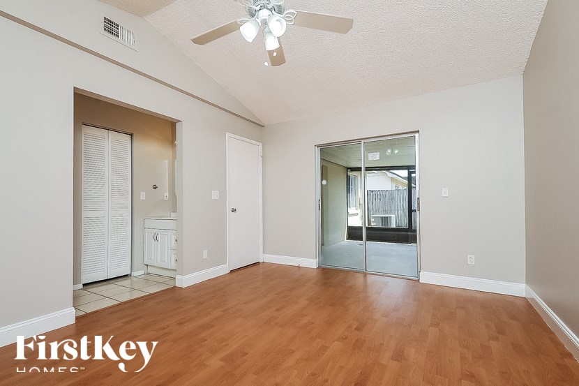 A room with wooden floors and a ceiling fan.