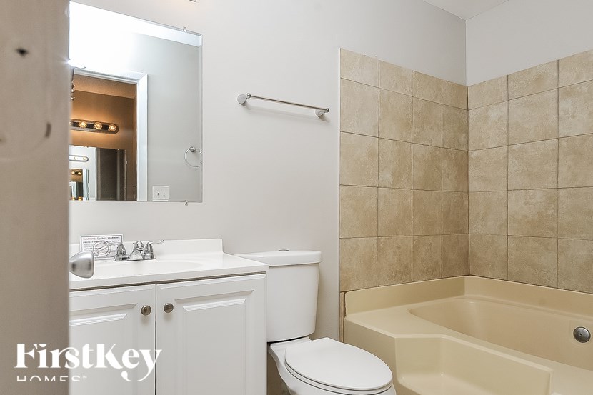 A bathroom with a white toilet, sink, and bathtub.
