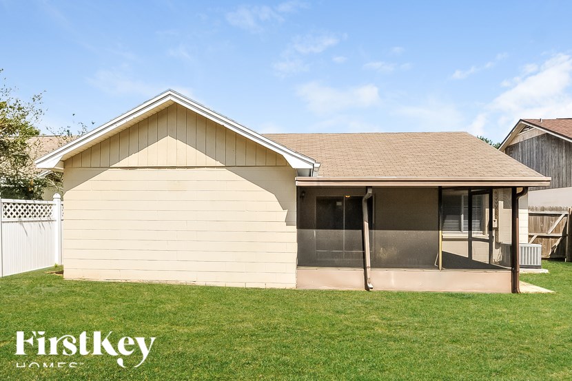 A house with a brown roof and a white fence.