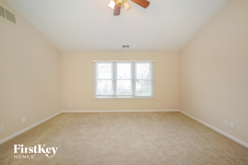 a bedroom with a ceiling fan and a window