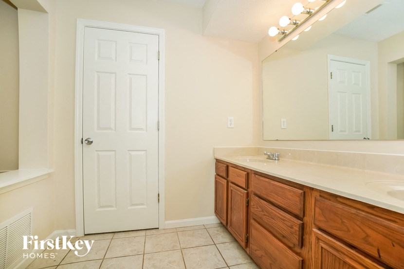 a bathroom with a sink and a mirror and a door
