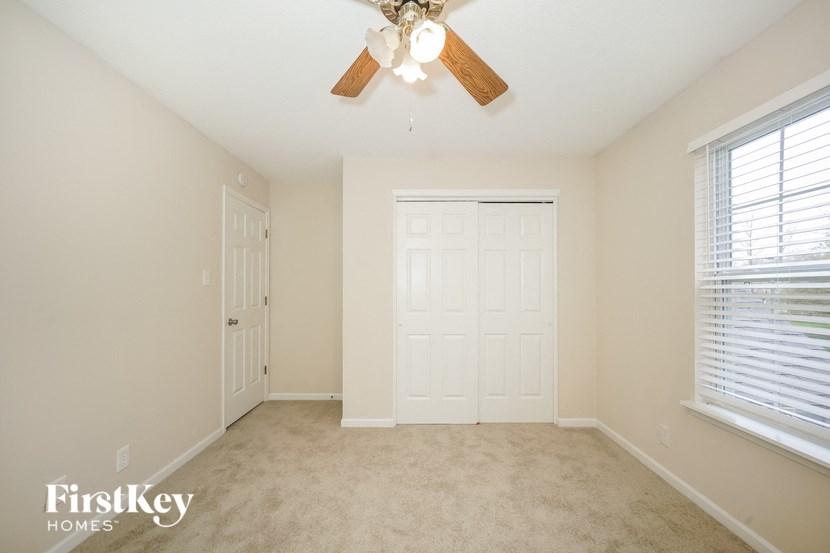 a bedroom with a ceiling fan and a closet