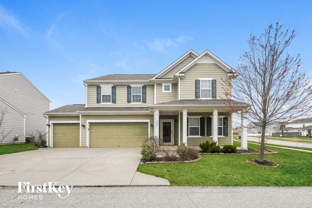 A two-story house with a garage is for sale.