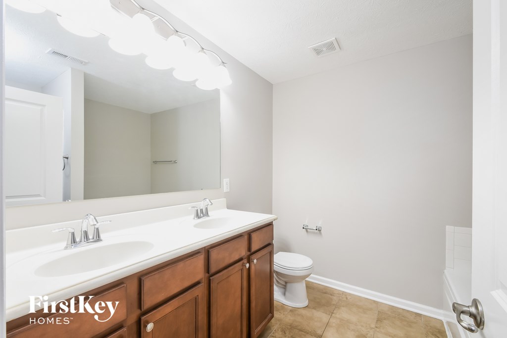 A bathroom with a white sink and a toilet.