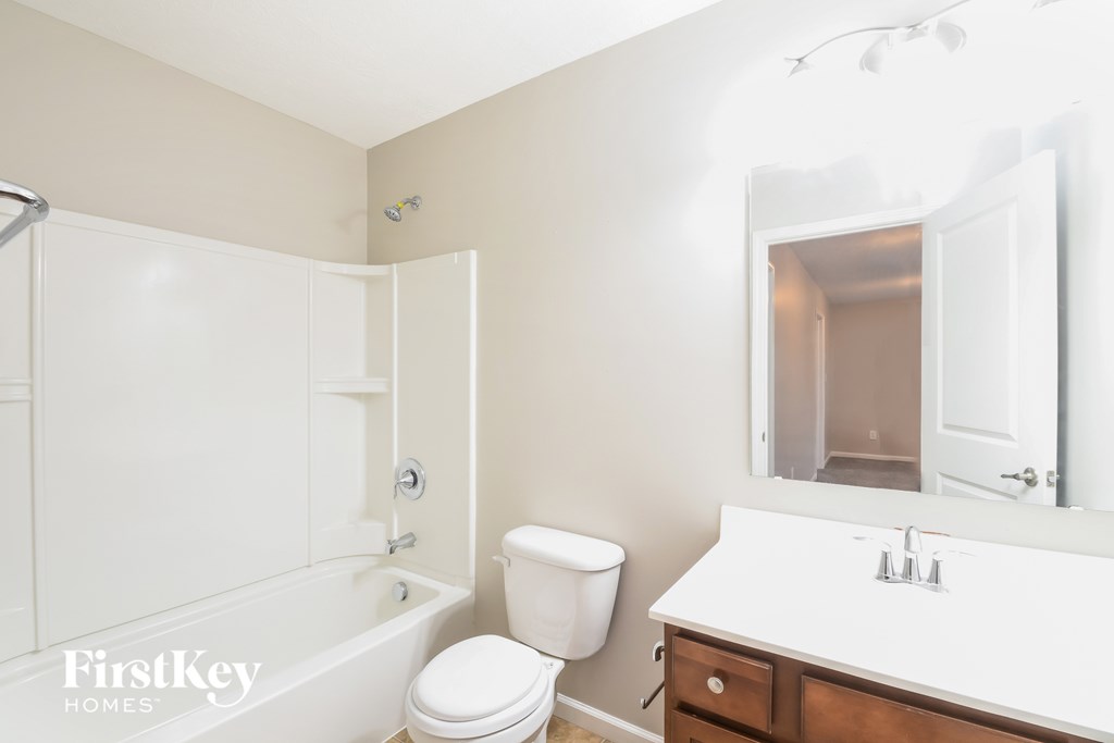 A white bathroom with a toilet, sink, and bathtub.