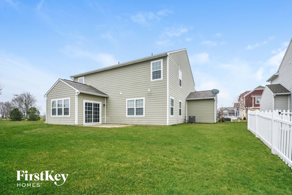A house with a white picket fence in the front yard.