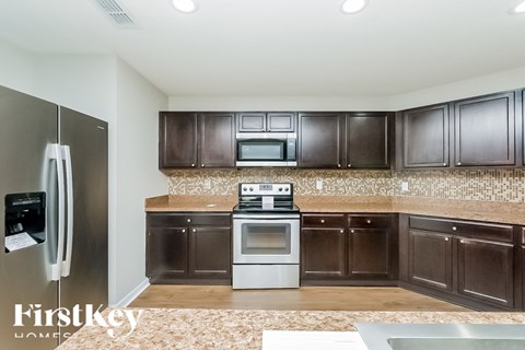A kitchen with brown cabinets and a stainless steel refrigerator.
