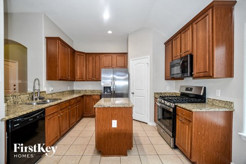 A kitchen with wooden cabinets and a granite countertop.