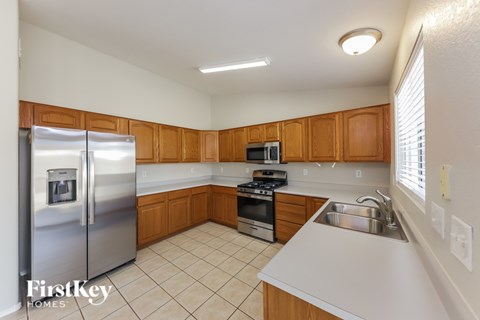 A kitchen with wooden cabinets and a stainless steel refrigerator.