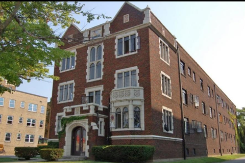 A red brick building with a white arched entrance.