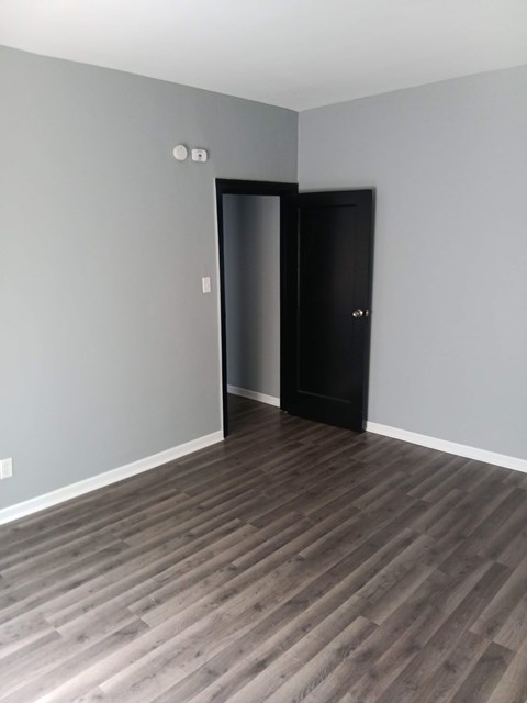 A room with a black door and a grey wall.